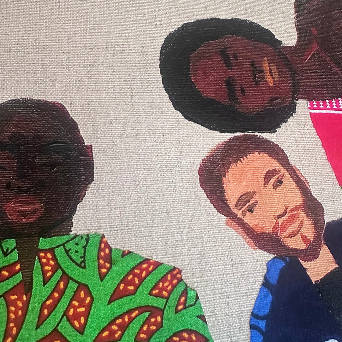 A close-up of a textured canvas print featuring stylized portraits of three men in colorful clothing against a light beige background.